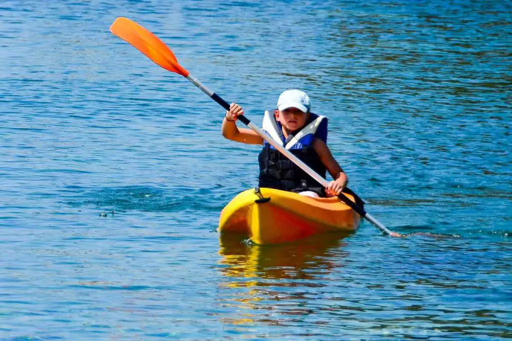 kayaking lessons. Boy with  life buoy suit in kayak lessons during summer vacations in an island of Greece