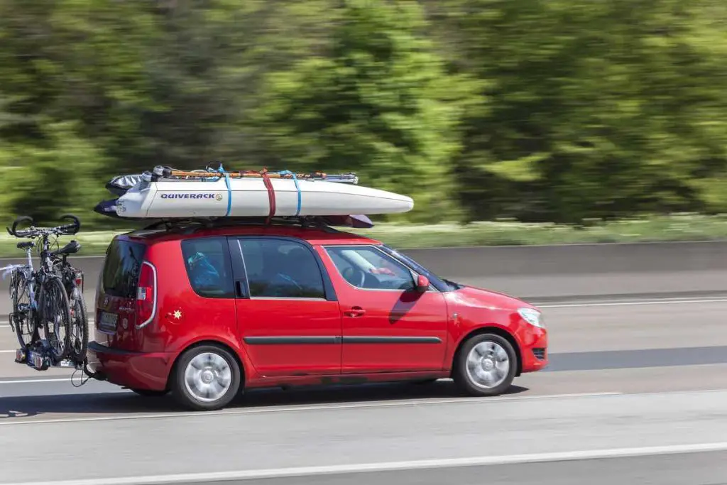 Frankfurt, Germany - March 30, 2017: Red Skoda Roomster packed with bikes and surfing stuff on the highway in Germany