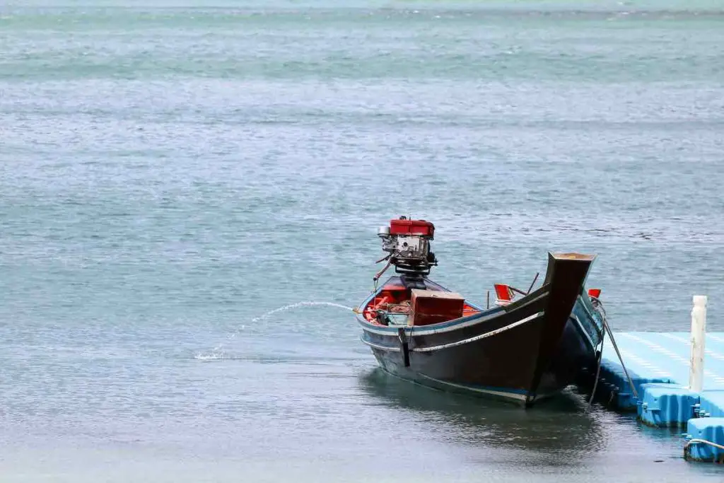 The wooden long-tail boats with automatic motors pump the water out from the boat , Parked with floating pier.