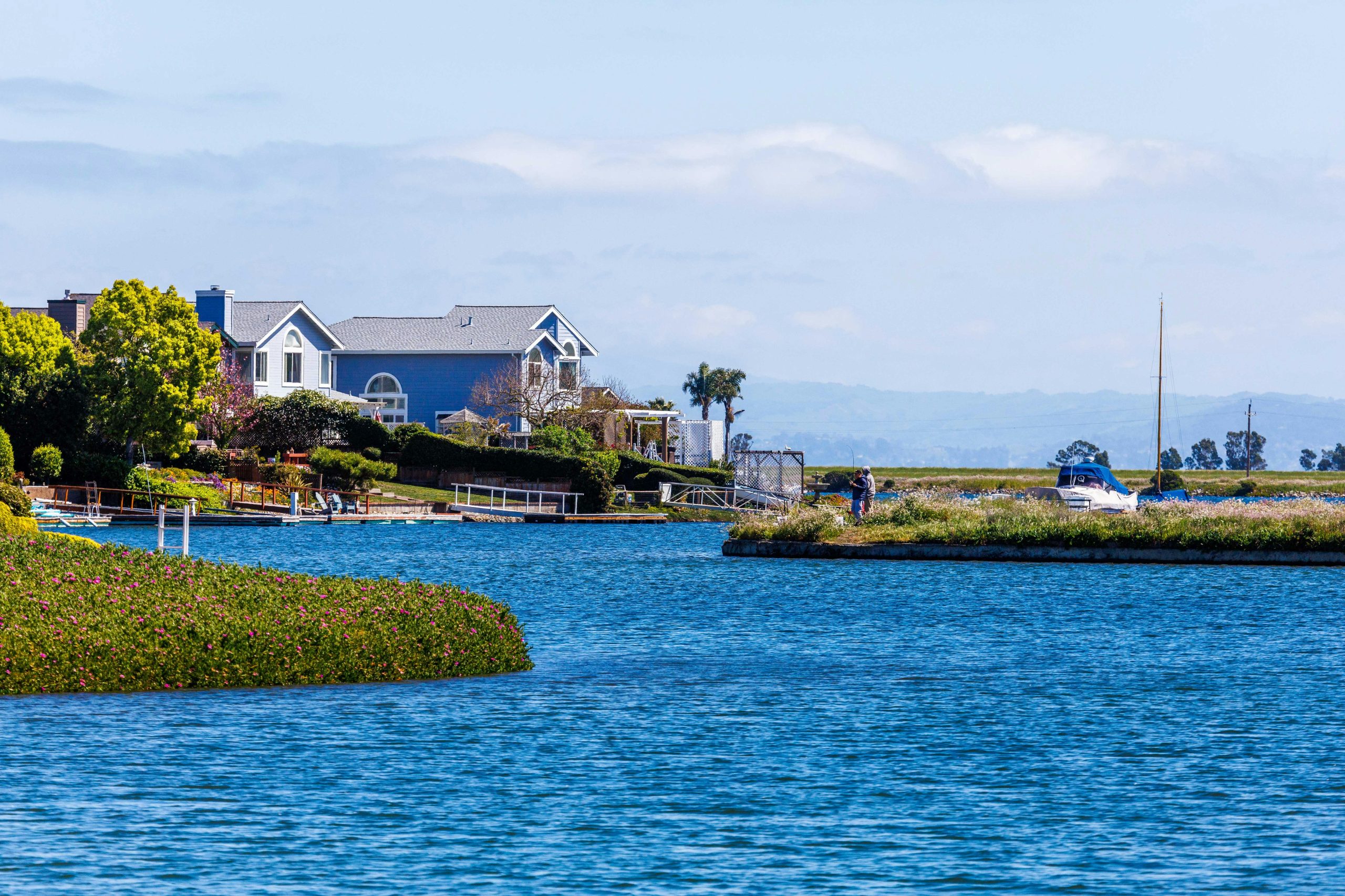 Charming lakeside house with a beautiful waterfront view, surrounded by greenery and serene water.