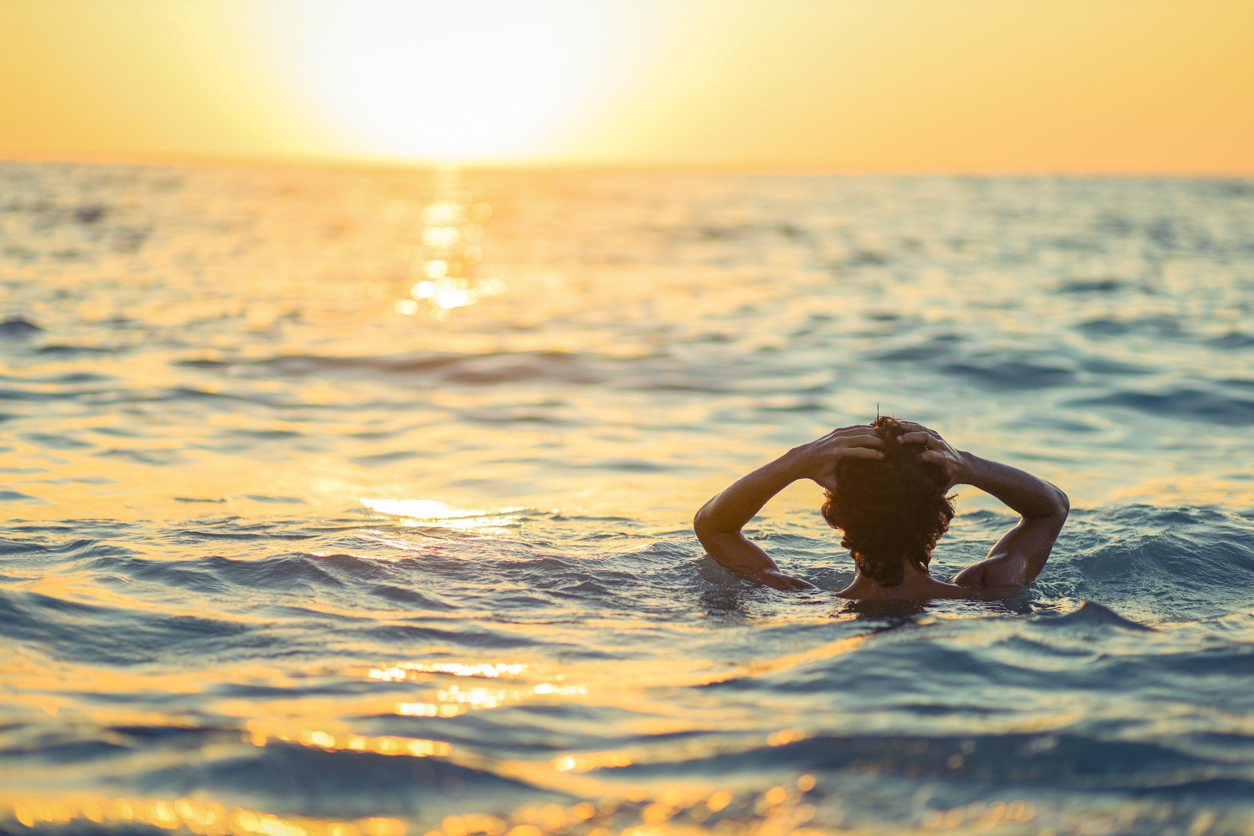 Tranquil scene of a person enjoying a sunset swim in the sea at Latakia, Syria.