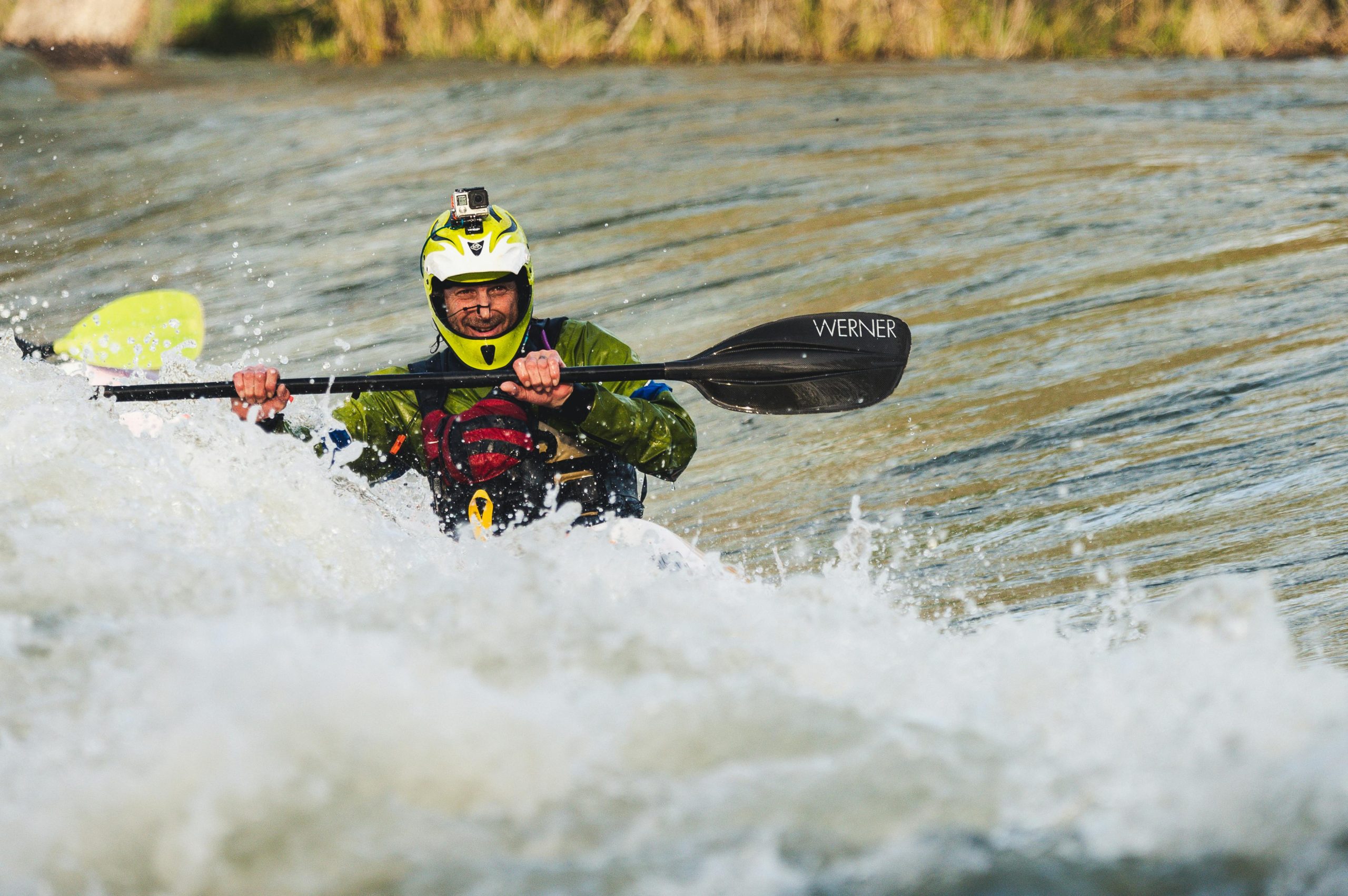 A kayaker skillfully navigates rapids, showcasing extreme water sports action.
