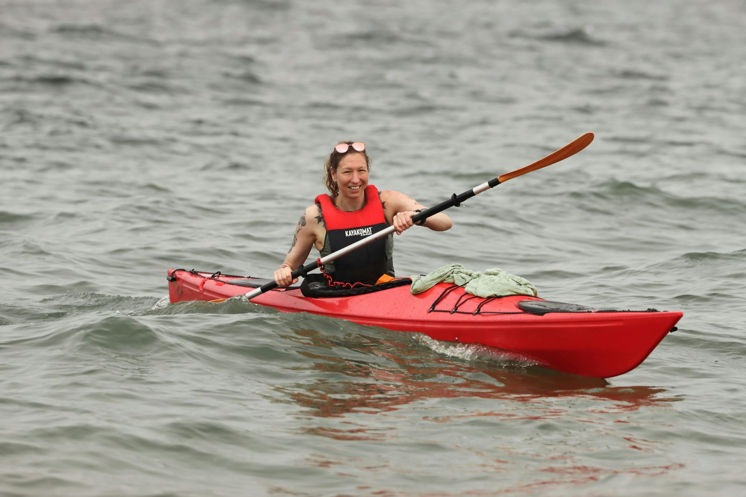 Exciting kayaking scene in Jönköping, Sweden with a woman paddling in red kayak.