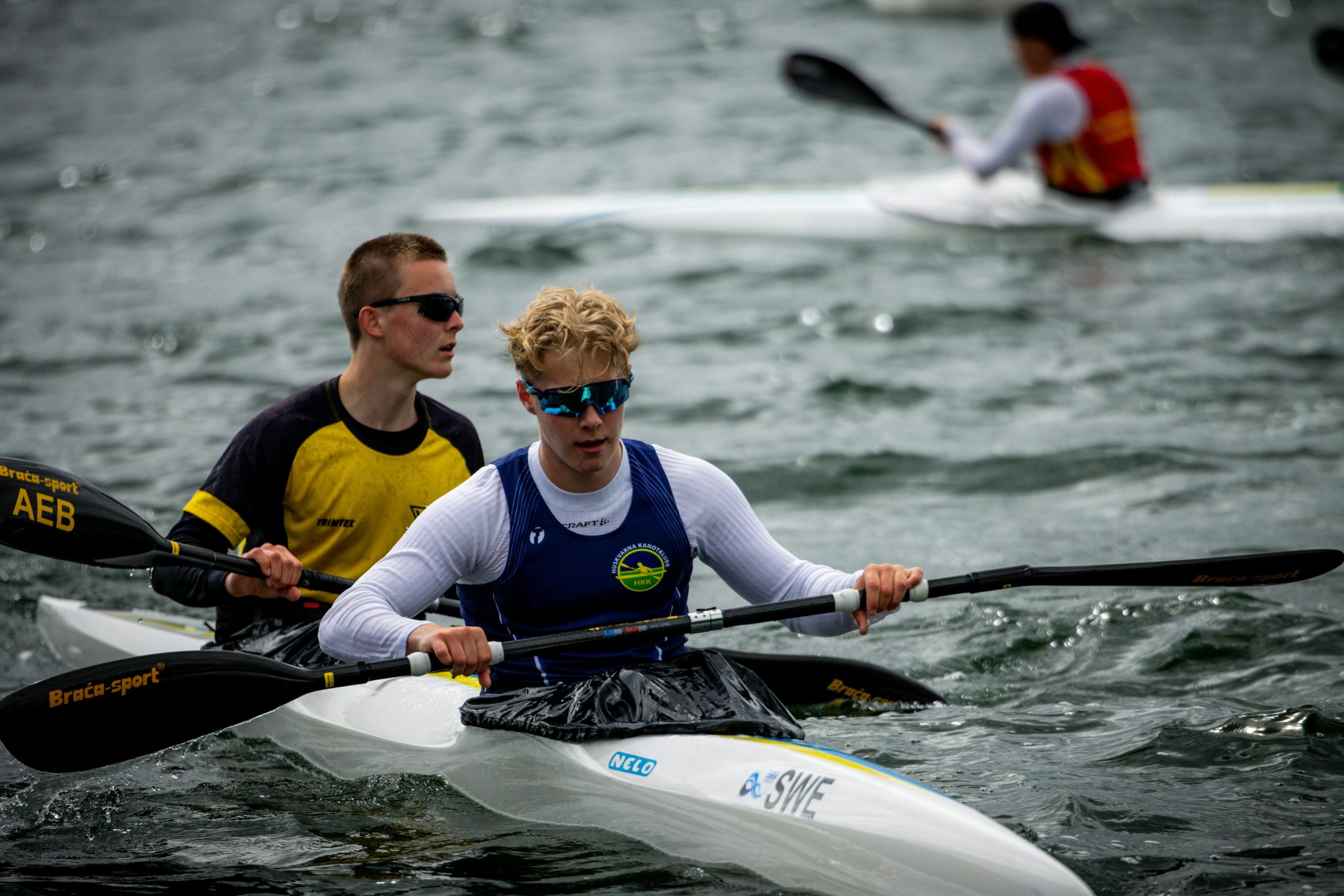 Intense kayaking competition on a wavy Swedish waterway, showcasing skill and determination.
