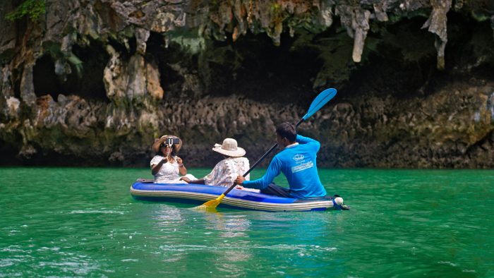 Group kayaking through stunning limestone caves in Krabi, Thailand.