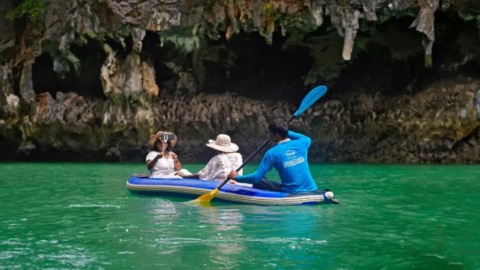 Group kayaking through stunning limestone caves in Krabi, Thailand.