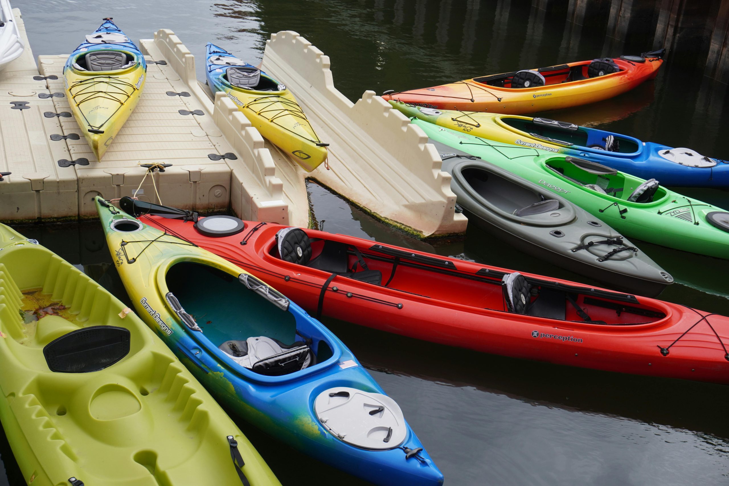 Vibrant kayaks moored at a floating dock, ready for aquatic adventure.